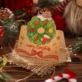 Vintage cartoon Christmas greeting card with wreath design on a rustic burlap mat - Christmas Wreath