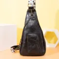 Vista detallada de un bolso de pecho de cuero PU negro con correa ancha bordada - Negro