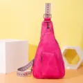 Detalle del bolso bandolera de piel sintética rosa con correa bordada étnica. - Rosa rojo