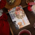 Christmas gold foil postcard featuring a festive wreath and dogs looking out a window - Christmas Friends