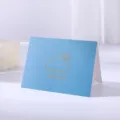 Minimalist blue greeting card with gold foil sun and cloud design. - Sky Blue