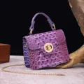 Detailed view showing the purple crocodile embossed texture and gold-tone twist lock - Colorful Purple