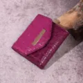 Primer plano de billetera fucsia para mujer con grabado de cocodrilo y barra dorada - Cocodrilo Fucsia (PG831)