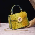 Close-up of yellow green crocodile embossed handbag featuring a gold chain strap detail - Colorful Blue & Yellow
