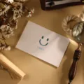 Carte de vœux créative blanche avec un visage souriant découpé et le texte SMILE - Style Souriant