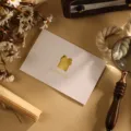Carte de vœux minimaliste blanche avec découpe cadeau dorée et texte Happiness. - Style Couronne de Bonhomme de Neige