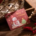 Festive red Christmas tri-fold greeting card featuring cute snowman and tree illustration - Snowman Style