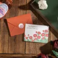 Tarjeta de felicitación floral con sobre naranja y diseño de flores rojas en acuarela - Felicidad Desbordante (Felicidad Desbordante Con Sobre) / 1 Hoja