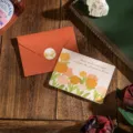 Elegante tarjeta de felicitación de flores con sobre naranja y texto en pan de oro - Escuchar Al Viento (Escuchar Al Viento Esperar La Floración) / 1 Hoja