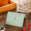 Close-up detail of a green Christmas greeting card with elegant gold foil Merry Christmas text - Christmas Wreath / 10 Sheets Set