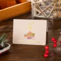 Detail shot of a small Christmas card featuring gold foil stamping and gift icons - Christmas Gift / 10 Sheets Set