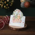 Gold foiled Christmas greeting card with festive snowman and house illustration - Christmas Hut