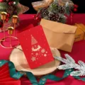 Elegante tarjeta de Navidad roja con árbol de pan de oro y sobre kraft en fondo festivo. - Estilo de Árbol de Navidad / Embalaje Individual con Sobre y Bolsa OPP / Rojo Navidad Retro