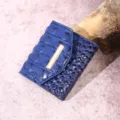 Primer plano de cartera de mujer azul con relieve de cocodrilo y detalle dorado - Cocodrilo Azul Marino (PG831)