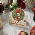 Tarjeta de regalo festiva vintage de Navidad con corona colorida y texto Merry Christmas - Colección de Navidad - Guirnalda y Campanas