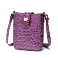 Detalle de bolso bandolera morado con estampado de cocodrilo y hebilla metálica dorada. - Púrpura profundo
