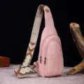 Detalle de un bolso bandolera rosa de cuero sintético con correa de estilo bohemio. - Bolso de Pecho Retro (PG812) / Rosa