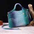 Primer plano de bolso vintage con motivo de cocodrilo multicolor y detalles dorados - Azul Pavo Real + Azul