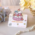 Cute 3D fold-out birthday card with pink cherry cake illustration and Happy Birthday text - Style 3 (2026022601)