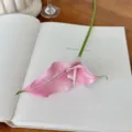Elegante tallo de cala artificial rosa sobre un libro abierto para decoración floral realista - Rosa rojo