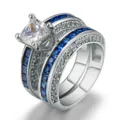 Primer plano de un conjunto de anillos de compromiso con circón cuadrado y detalles azules. - Talla 5 / Oro Blanco Circonita Azul