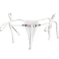 Primer plano de tanga blanco transparente con abalorios de letras de estrás y lazos laterales. - Talla única (Estándar sin letras) / Blanco