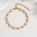 Elégant bracelet en acier titane plaqué or avec inserts en perles blanches ovales. - Style Perle Ovale