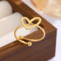 Makrodetail eines minimalistischen goldenen Herzrings auf einer hölzernen Schmuckschatulle - Hohles Herz-Stil (CXR946-F)