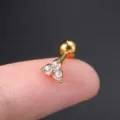 Detailweergave van een goudkleurige zirkoon oorknopje op een vingertop voor schaal - Gouden Rond