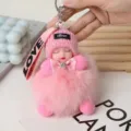 Detailed close-up of fluffy pink pom-pom sleeping doll keychain with knitted hat. - Pink (14cm/37g)
