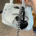 Mini borsa in pelle testurizzata bianca con ciondoli a cuore e catene di perle. - Nero
