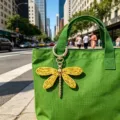 Primo piano di un ciondolo borsa libellula intrecciato a mano su borsa verde in città. - Giallo