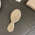 Detailed view of the stylish polka-dot pattern on the back of the cushion hair brush - Large Long Handle / White