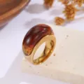 Detailansicht des bernsteinfarbenen Harzsteins auf einem goldenen Edelstahlring. - Größe 7 / Bernstein Marmoriert (Stil B)