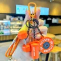 Primo piano dettagliato di un portachiavi da fitness con ciondoli manubri e shaker. - 16cm / 55g / Arancione