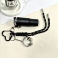 Leuke gevlochten sleutelhanger met mini-waterfles en koptelefoonhanger voor stijlvolle tas. - Zwart