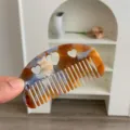 Detailed close-up showing the heart-shaped cutouts on this amber acetate hair comb - Heart Cutout Half Moon Comb / Small (8.8x4.8cm) / Blue Brown