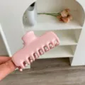 Primer plano de una pinza para el cabello rosa brillante con diseño de doble resorte. - Rosa Cremoso