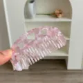 Macro view of a portable pink marble acetate hair comb featuring cute heart cutouts - Heart Cutout Half Moon Comb / Small (8.8x4.8cm) / Transparent Pink