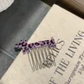 Detailed macro view of a purple leopard print dog hair comb made from premium acetate. - Purple Leopard