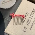 Macro view of a cute red leopard print dog acetate hair comb placed on a linen book - Red Leopard