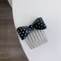 Detailed view of a black polka dot acetate bow hair comb with polished silver teeth - Black Polka Dot Comb / Black