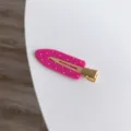Detailed view of a hot pink polka dot hair clip with a sturdy gold-tone metal base - Rose Red