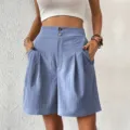 Detail view of high waist pleated wide leg shorts in blue with double buttons and pockets. - S / Bottoms / Light Blue
