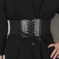 Dettaglio di una cintura elastica a corsetto nera con fiocco in nastro e pieghettata - Nero