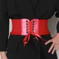 Dettaglio del design stringato di una cintura elastica a corsetto rossa su un cappotto. - Rosso