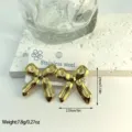 Macro view of stylish gold striped bow earrings including dimensions and weight information - Horizontal Striped Bow (ES824) / Gold