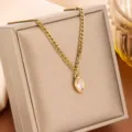 Primo piano di una collana in acciaio al titanio dorato con ciondolo marquise - Stile Strass Champagne Marquise (81407) / Champagne