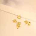 Primo piano di piccoli ciondoli a forma di pesce d'oro per la creazione di gioielli fai da te - Pesce Intagliato (002)