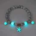 Detailed view of luminous beaded bracelet featuring glowing cyan starfish charms - Bracelet / Gold (White Turq Cyan)